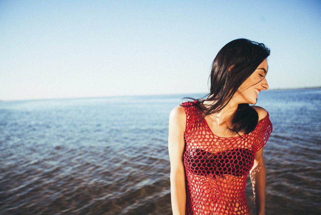 girl smiling in front of ocean
