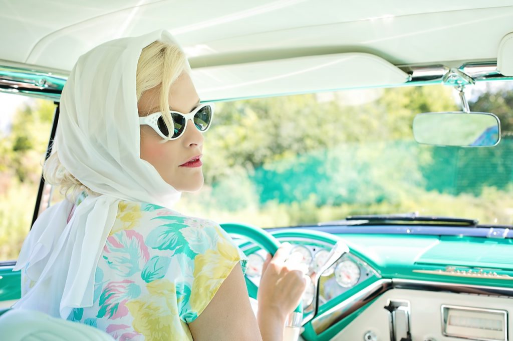 woman in a car in a 1960s vintage dress