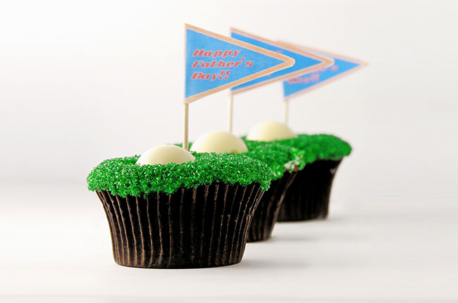 Homemade DIY golf cupcakes with personalized flag toppers that say "Happy Father's Day!!"