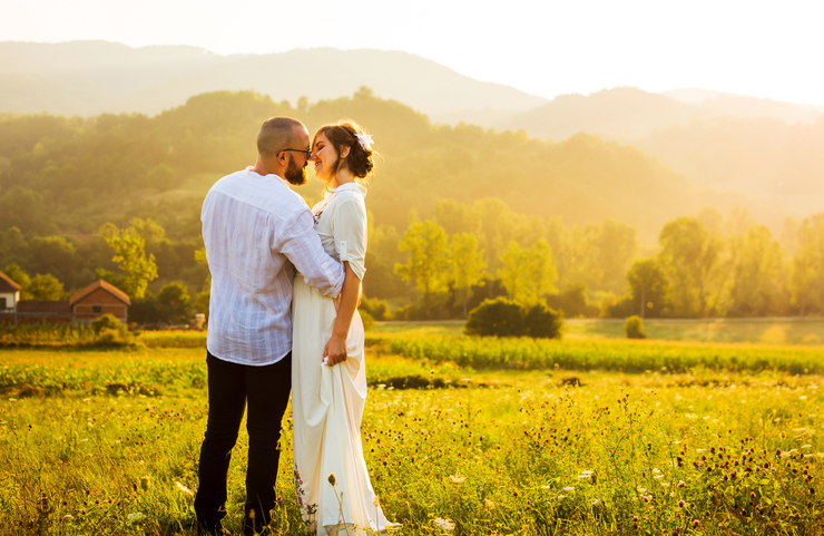 Couple kissing during a romantic sunset in the field