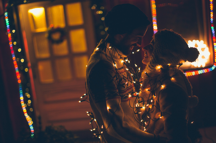 Couple kissing in Christmas lights