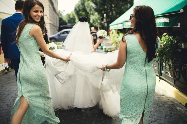 Bridesmaids holding up wedding veil