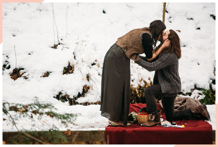 couple getting engaged on red blanket christmas engagement photo