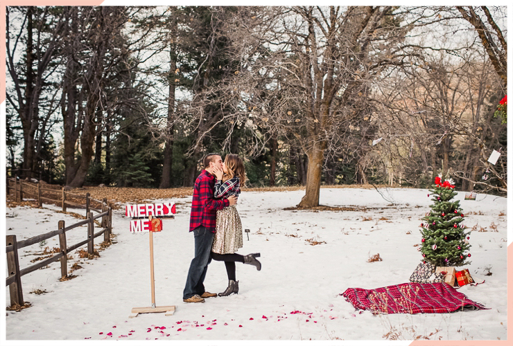 couple kiss in the snow christmas engagement photo