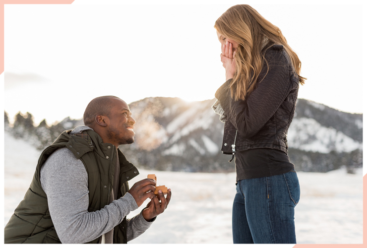 guy presenting engagement ring in snow christmas engagement photo
