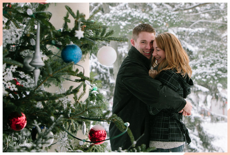 hug by a tree christmas engagement photo