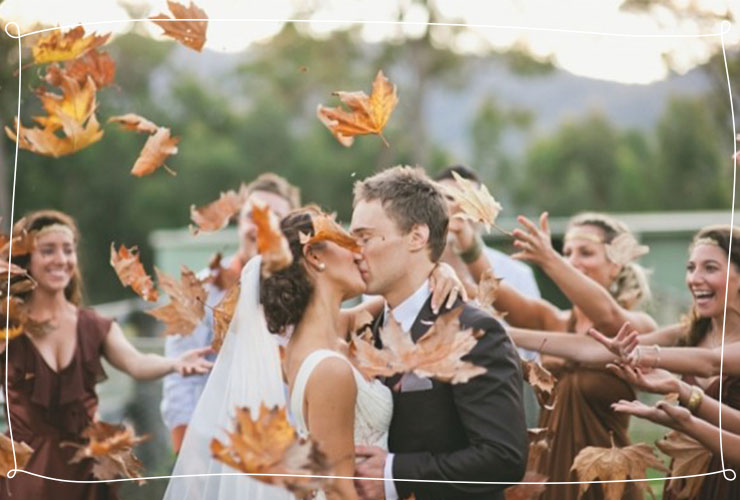 Couple kisses under falling leaves 