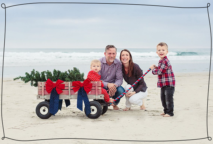 Family with red wagon on the beach