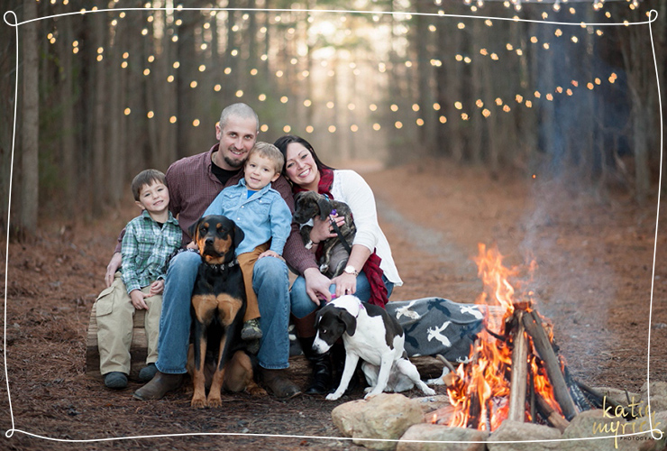 Family sits around a campfire in the woods