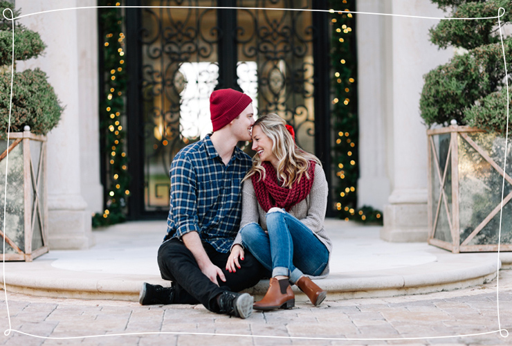 Couple in front of a designed door with Christmas lights