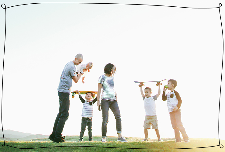 Family photo on grassy hill with skateboards 