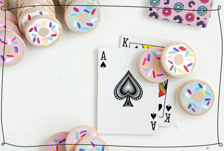Painted donut poker chips are spread out on a table
