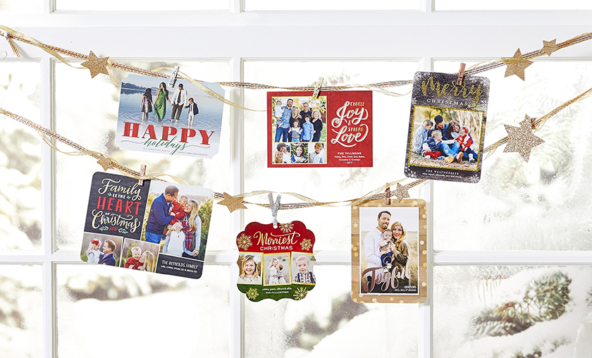 family christmas cards hanging at window