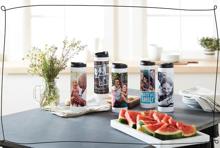 Travel mugs personalized with family photos sit on a counter by a tray of watermelon