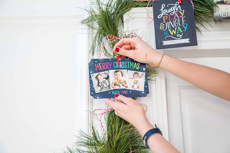 clipping holiday cards onto christmas garland