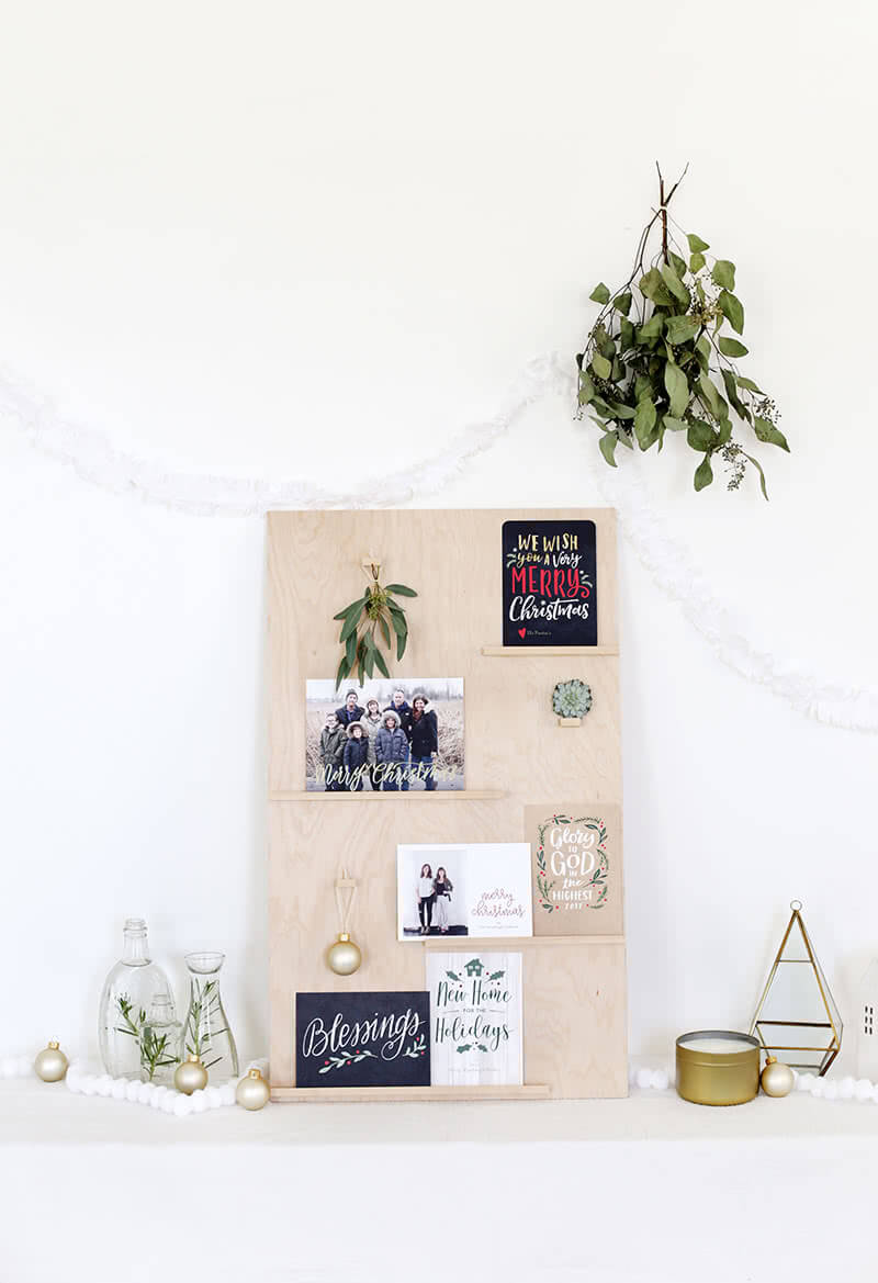 diy christmas card display with ornaments and greenery