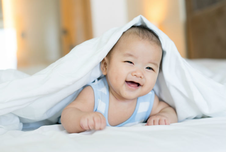 baby hiding under blanket