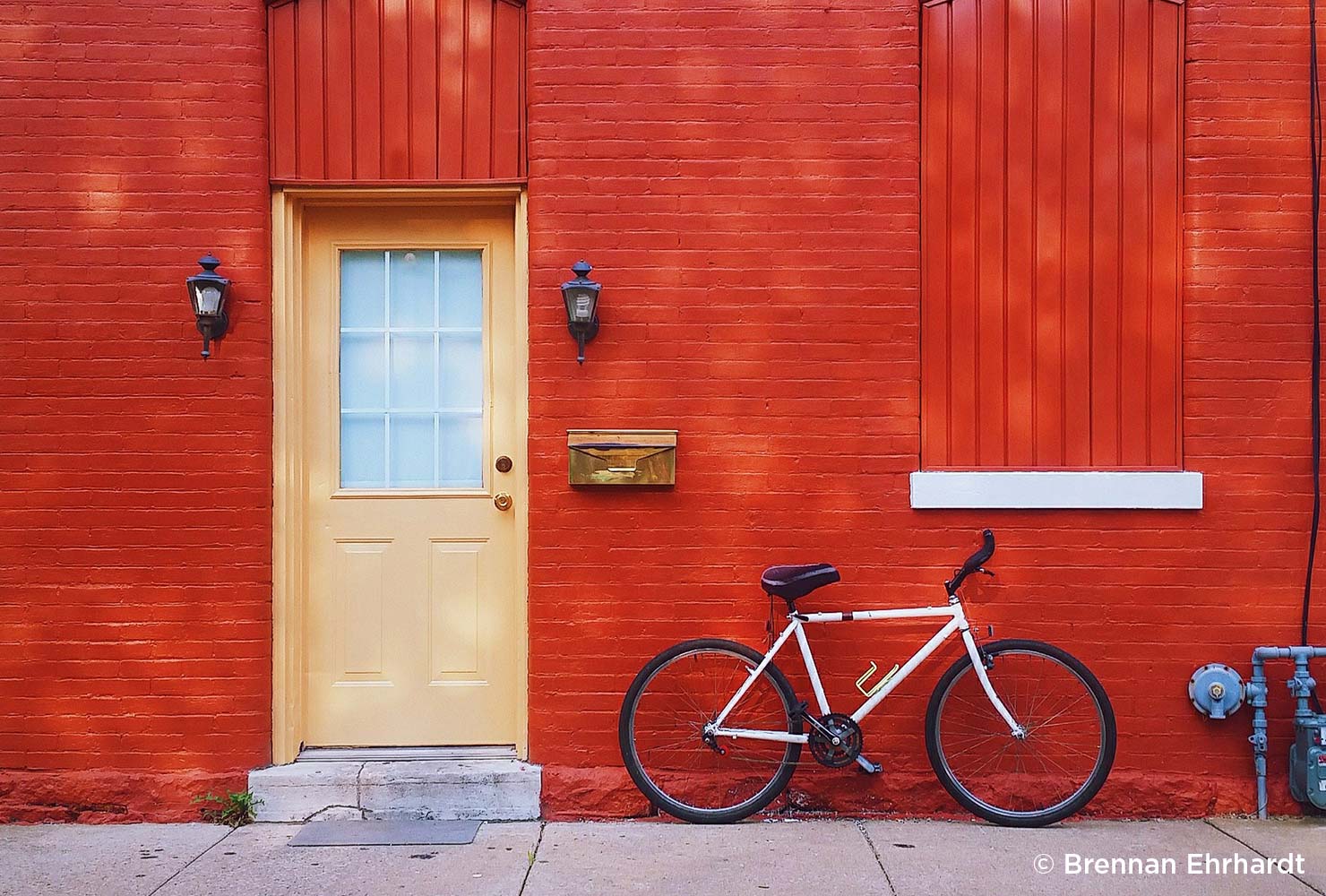 bike lays against a red wall