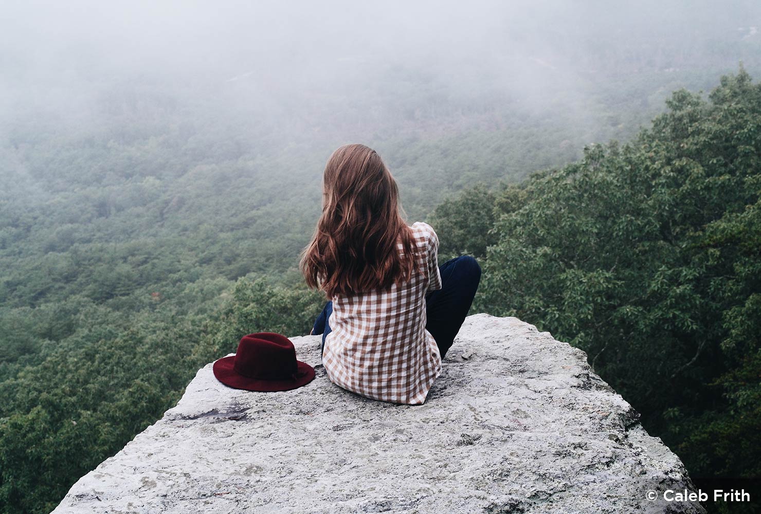 girl with red hat looks at nature