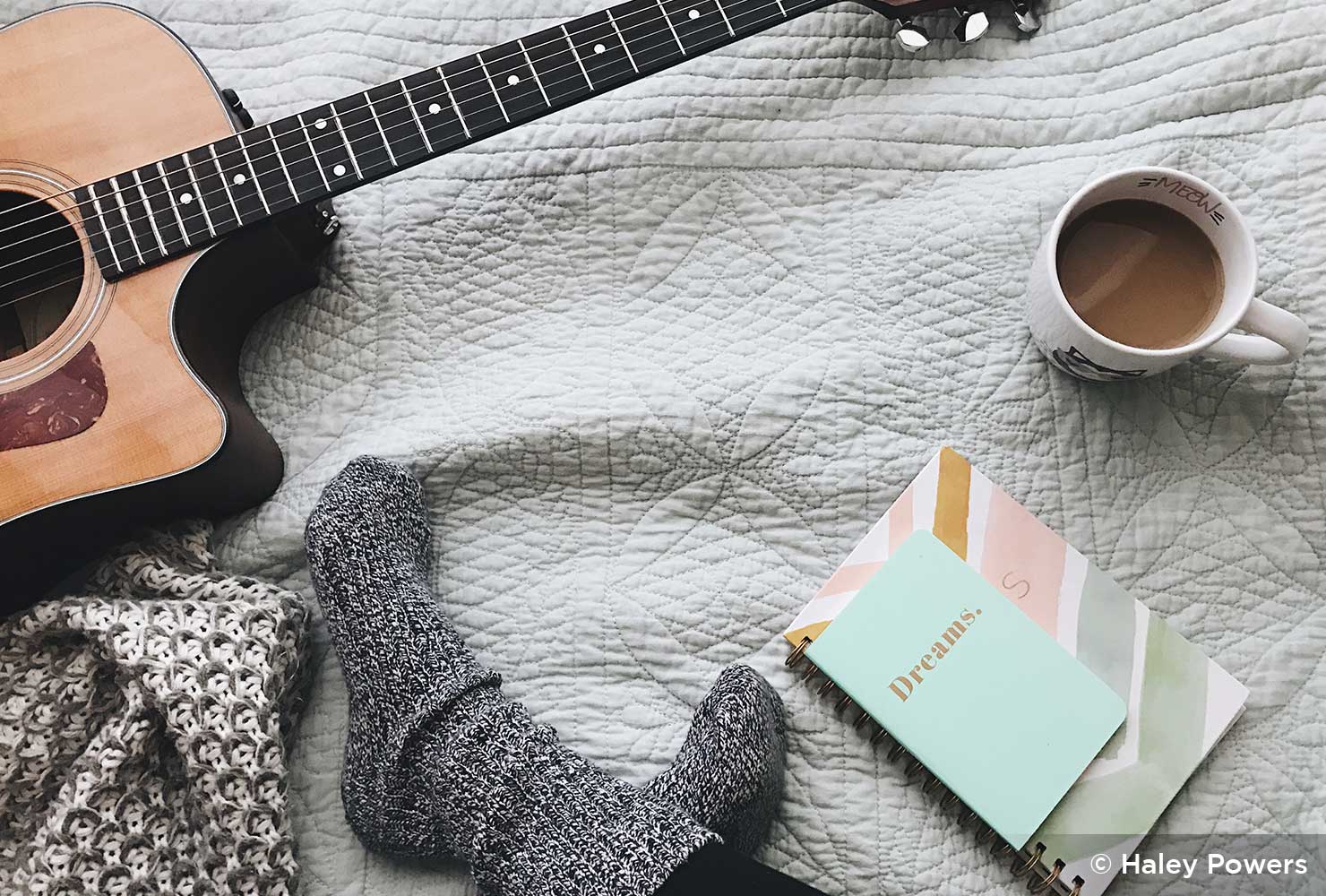 person's feet with a guitar and coffee