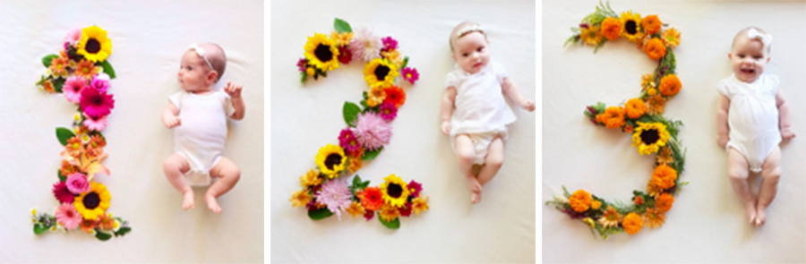 Baby laying next to flower numbers